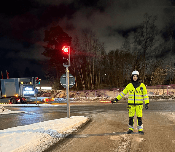 Flaggvakt reglerar trafiken vid en vinterväg i Örebro