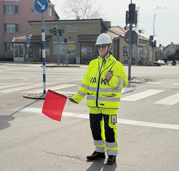 Flaggvakt leder trafiken vid en korsning