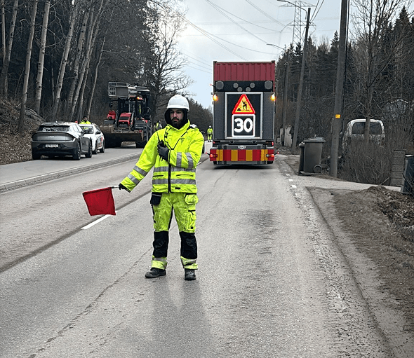 Flaggvakt reglerar trafiken vid vägarbete i Småland