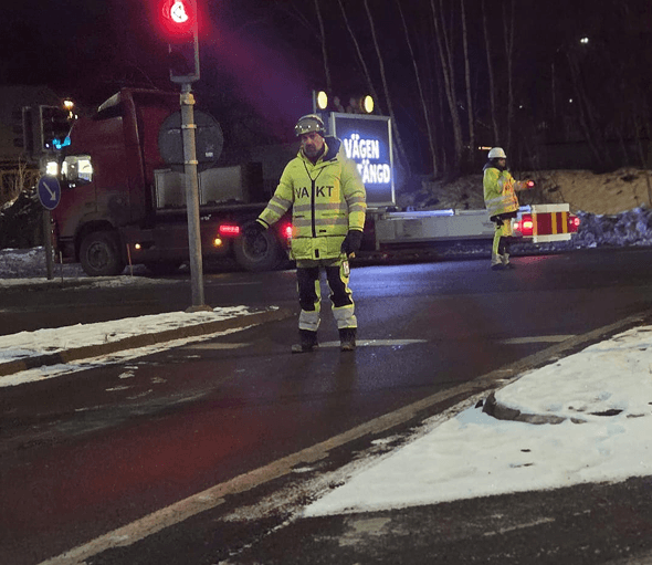 Flaggvakt leder trafiken vid ett nattarbete i Södermanland