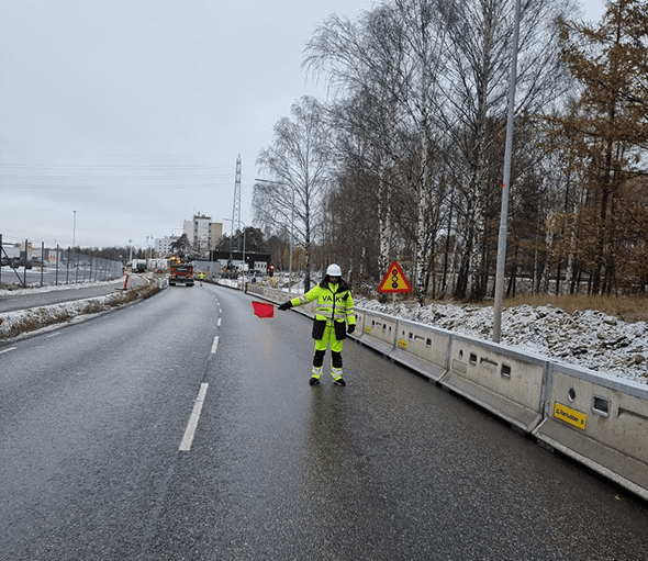 Flaggvakt reglerar trafiken vid vintervägarbete i Kalmar