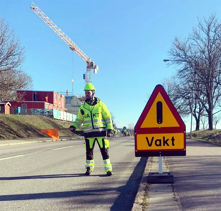 Flaggvakt och varningsskylt vid vägarbete